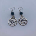 Pentacle earrings with black beads on a light gray background