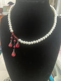 Vampire Pearls glass pearl necklace with asymmetric dark red crystal drops on display