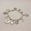 Silver-tone celestial charm bracelet with crescent moon, sun, star and hexagram charms on a link chain
