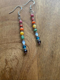 Colorful beaded earrings on a wooden surface.