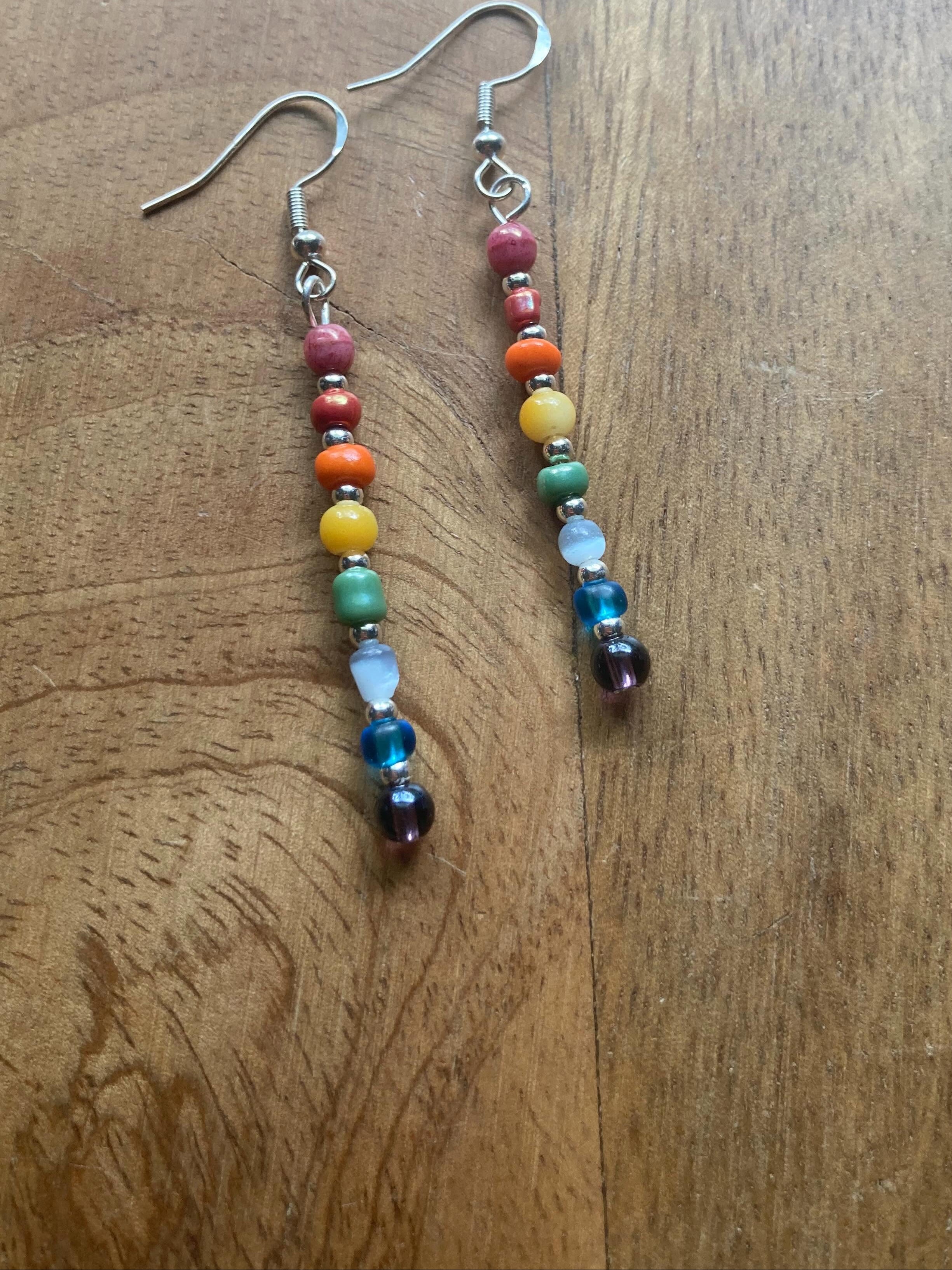 Colorful beaded earrings on a wooden surface.