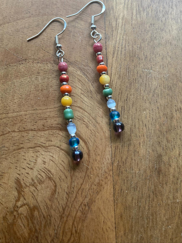 Colorful beaded earrings on a wooden surface.