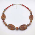 Ancient Earth Statement Necklace featuring petrified wood slabs, soapstone center bead, red carnelian rounds, and silver spacers
