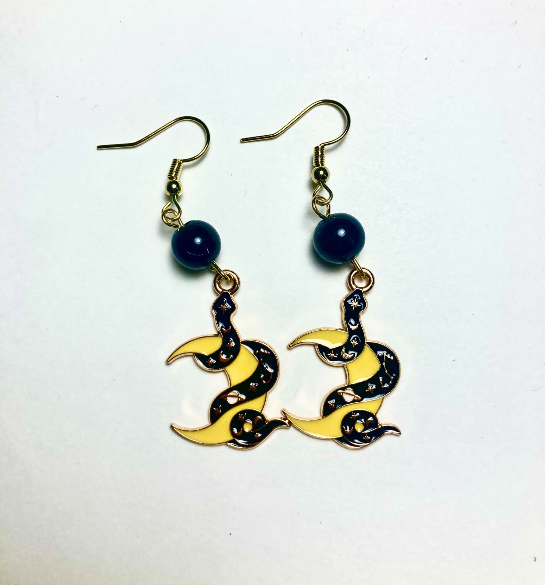 Dark enamel serpent and golden crescent moon drop earrings with black glass beads and 14k gold plated hooks